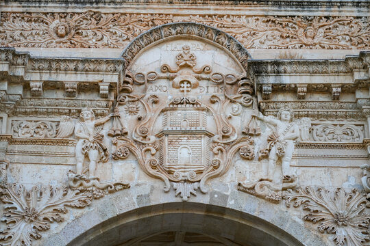 Close up of the stone carved coat of arms and baroque sculptures on Saint Nicholas Cathedral facade in Sassari Sardinia, Italy