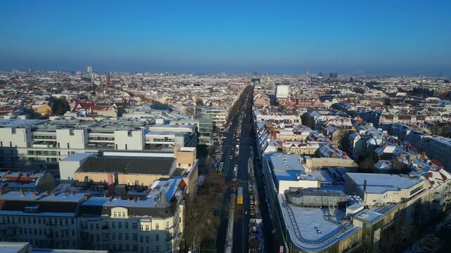 berlin city showing snow covered rooftops, buildings, and a long shopping street schloss str in winter. Stunning aerial view panorama overview drone
