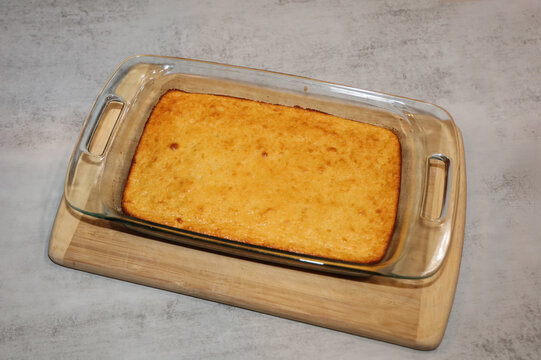 A freshly baked corn bread in a glass baking pan.