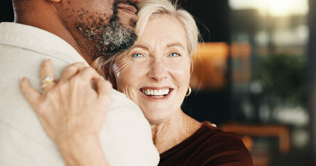 Fototapeta premium Hug, smile and interracial couple in home with trust, connection and relationship wellness. Mature man, woman and embrace with partner for love, security and commitment together with funny portrait