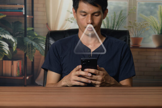 Young Man Using Smartphone at Desk in Cozy Indoor Environment with Plants