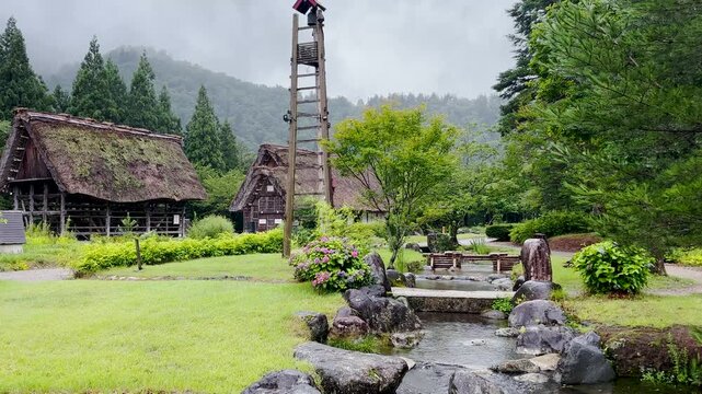 Traditional Japanese farmhouse with flowing spring water on rainy summer day