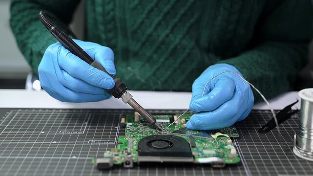 Closeup of expert soldering a green PCB board using precision tools. Ideal for electronics, circuit repair, engineering, tech