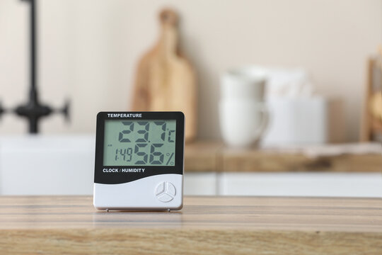 Digital indoor thermometer and humidity meter on wooden table