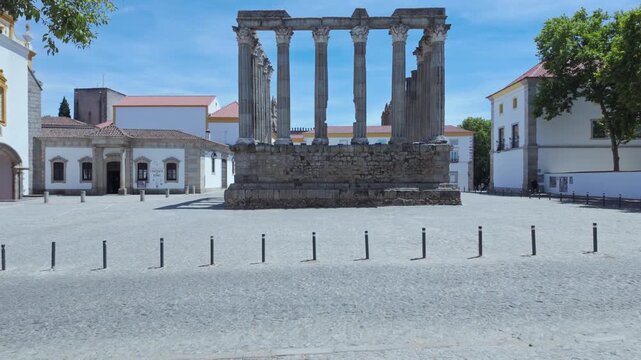 Pan forward of the ancient ruins of the UNESCO recognized Roman Temple of Evora from the time of the Roman Empire rule of the Iberian Peninsula, in the square where the Inquisitions transpired