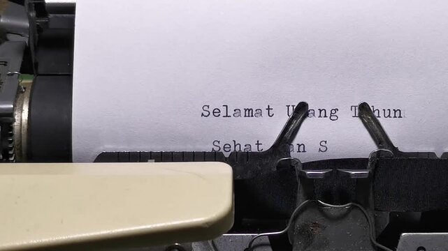 Front view of a vintage typewriter typing the Indonesian phrase Sehat dan Sukses Selalu for birthday wishes