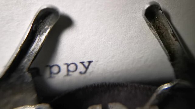 Extreme close-up of a vintage mechanical typewriter typing a Happy Birthday greeting on a blank sheet of paper. Retro analog communication and celebration concept.