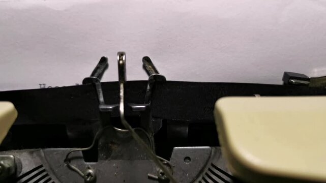Front view of a vintage typewriter typing a desperate Help message on white paper.