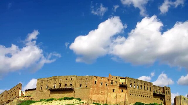 Cinematic view of the Historic Erbil Citadel, locally called Qelat. World Heritage center and UNHCR world heritage site. yellow-brick defensive walls and historical facades stand on a high tell mound.