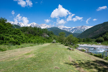 河川敷公園と残雪の北アルプス　長野県白馬村 © RATM