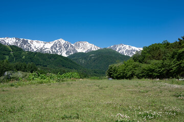 河川敷公園と残雪の北アルプス　長野県白馬村 © RATM
