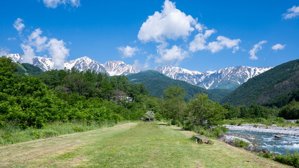 河川敷公園と残雪の北アルプス　長野県白馬村 © RATM