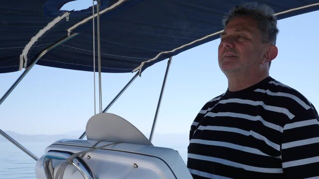 Mature captain steering sailboat at sea
