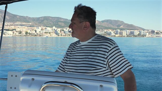 Senior man steering a sailboat at sea