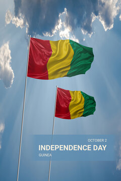 Two flags of Guinea in blue sky with clouds for National holiday