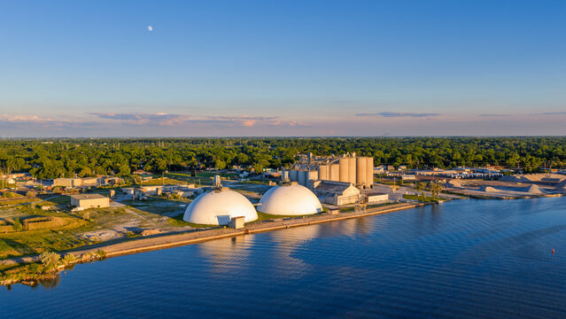Aerial view industrial port with domes and silos at sunset along Saginaw river