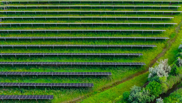 Solar panels generating clean energy on green hill