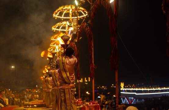 Ganga aarti, Portrait of young priest performing holy river ganges evening aarti at assi ghat in traditional dress with hindu rituals.