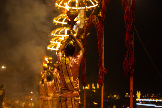 Ganga aarti, Portrait of young priest performing holy river ganges evening aarti at assi ghat in traditional dress with hindu rituals.