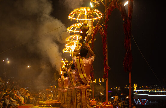 Ganga aarti, Portrait of young priest performing holy river ganges evening aarti at assi ghat in traditional dress with hindu rituals.