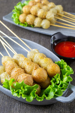 Cilor served on a plate, Cilor is a distinctive Indonesian street food consisting of aci (tapioca) skewers fried with egg, served with spicy chili sauce.