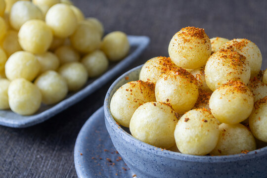 Chewy and delicious Indonesian street food Cimol Kentang served in a grey bowl sprinkled with spicy chili powder
