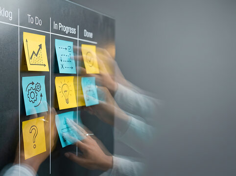 Business team collaborating on a kanban board with colorful sticky notes for agile project management