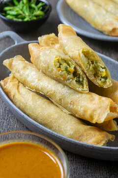 Lumpia bakwan, Crispy Indonesian fried spring rolls stuffed with savory vegetables, served with spicy peanut dipping sauce and fresh green chilies
