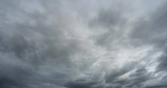 Dark clouds fill the sky, heavy and brooding. They stretch wide, swirling with low, menacing weight. The atmosphere feels thick with impending storm. Gloomy skies suggest danger, drama, or tension