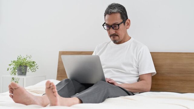 ノートパソコンで仕事をする50代の日本人男性
