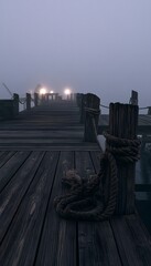 Fototapeta premium Mysterious pier glows beneath fog a tranquil seascape evokes peaceful nautical reflections