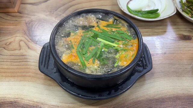 K-food traditional Korean hot boiling oyster soup (Gul Gukbap) in a black stone pot 굴국밥 굴뚝배기 보양식