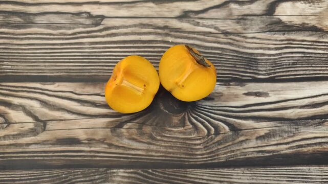 A fresh persimmon or Diospyros kaki on a wooden table