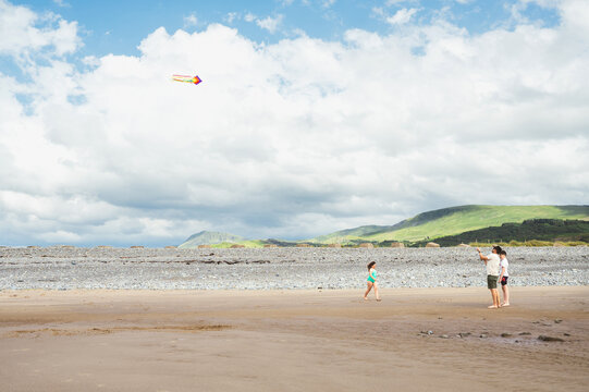 Family enjoying kite flying on a quiet beach