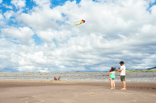 Father and daughter flying a colorful kite together