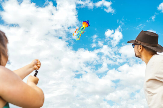 Father and child flying a kite on a sandy beach