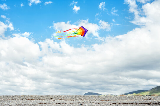 Colorful kite flying above a cloudy landscape