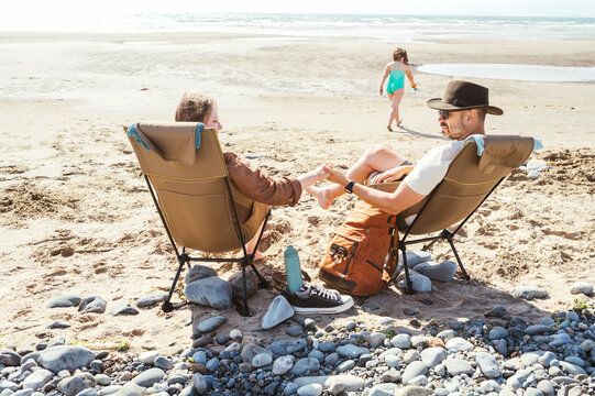 Couple relaxing together in camping chairs outdoors