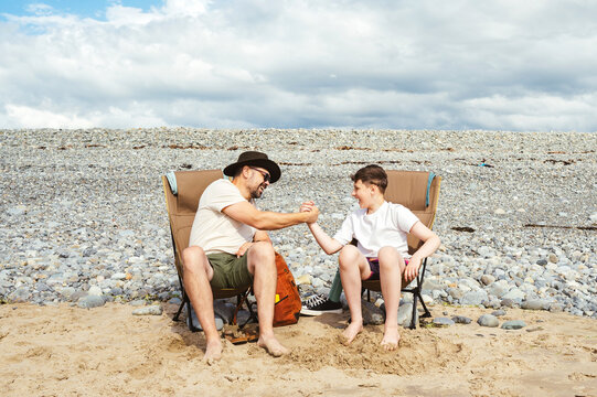 Parent and teenager sharing a playful moment on the beach