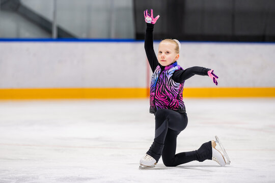 Young girl practices figure skating on the ice