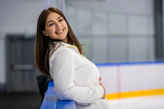 Cheerful young woman at the ice skating rink