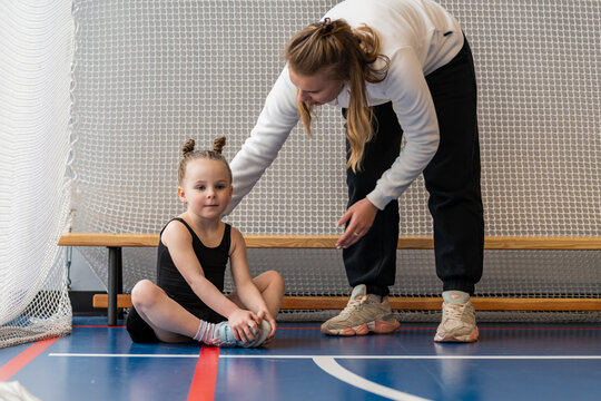 Coach helping a young girl during gymnastics practice