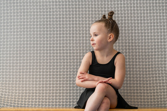 thoughtful little girl in a swimsuit patiently waits for training