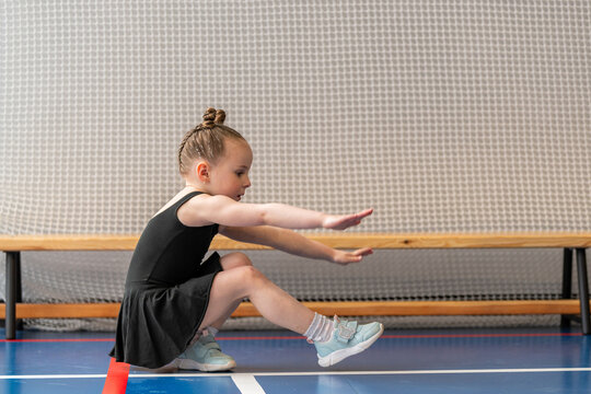 Focused young girl practicing balancing in a gym
