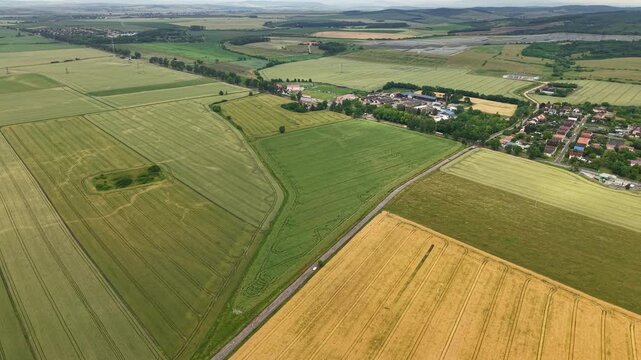 An aerial perspective captures the diverse patchwork of agricultural fields and rural village settlements spanning the countryside in Hungary, Europe.
