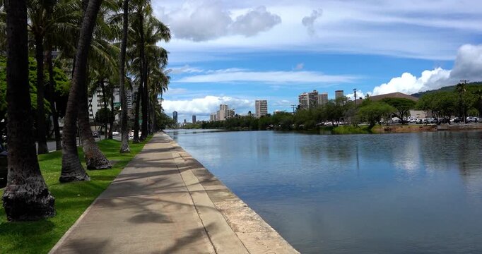 Scenic view of Ala Wai Canal with palm trees and condos in Honolulu, Hawaii