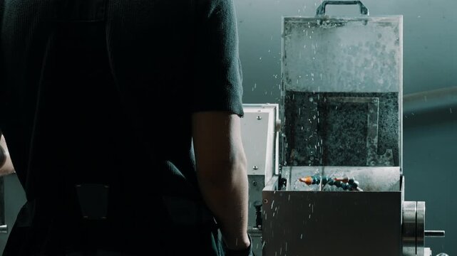 Machine Operator at Work with Coolant Spray in Industrial Workshop
