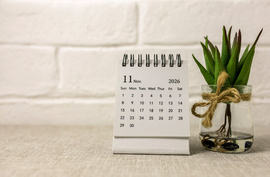 Desk calendar for November 2026 on the table.