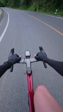 View from a cyclist's perspective on a road, showcasing a modern bicycle with a GPS device, ideal for outdoor adventure and fitness themes.