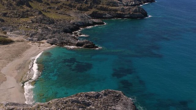 Crete coastline with clear water on a sunny day in summer, drone aerial video
